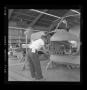 Primary view of [Bell employee working on the nose assembly of the XH-40]