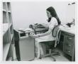 Photograph: [Woman Processing a Magnetic Tape Cassette into a Tape Editing System]