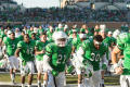 Photograph: [Mean Green Football Players Running on Field]