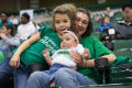 Photograph: [Woman and Two Children Enjoying UNT Basketball Game]