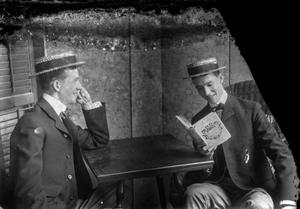 Primary view of object titled '[Two Men Read on Porch, Smiling]'.