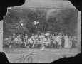 Photograph: [Men, Women, and Children in front of a grove of trees]