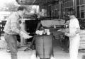 Primary view of [Jack McClendon helps a student during a raku demonstration.]