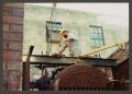 Photograph: [Construction Worker with Metal Tank #2]