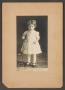 Primary view of [Photograph of a Young Girl Standing Next to a Chair]