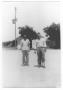 Photograph: [Two Young Men Standing in the Road]