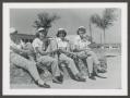Photograph: [Four WASPs sitting on Wishing Well at Avenger Field]