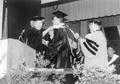 Photograph: [Vivian Blevins and Oswall Harman adjust Reggie Brewer's graduation r…