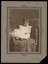 Photograph: [Portrait of a Child on a Covered Chair]
