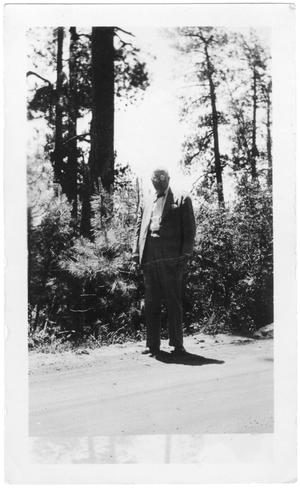 Primary view of object titled '[Col. Hugh B. Moore walking along a dirt road]'.
