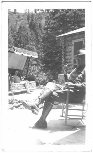 Primary view of object titled '[Col. Hugh B. Moore relaxing near the cabin]'.