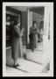 Thumbnail image of item number 1 in: '[Sheila Emery Allen looking at her reflection in mirror near storefront]'.