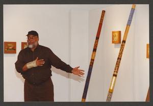 Primary view of object titled '[Alonzo Davis Gesturing Toward Displayed Artworks]'.