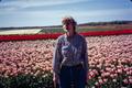 Photograph: [Woman Standing in Front of Tulips]