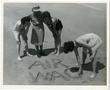 Photograph: [Women's Auxiliary Corps Members Writing in Sand on the Beach]