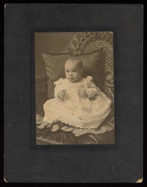 Primary view of object titled '[Unknown Child in a Cushioned Wicker Chair]'.