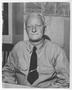 Photograph: [Admiral Chester W. Nimitz Sits at a Desk]