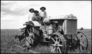 [Man and two girls on a tractor]