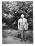 Photograph: [A man with gray hair wearing a light colored suit.]