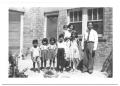 Photograph: [Hispanic Family in Front of a Brick Building]