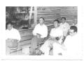 Photograph: [Class of Hispanic Men Sitting in a Log School House]