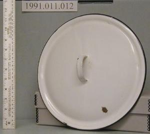 Primary view of object titled '[Lid to a pot. White enamel with black trim on edge.]'.