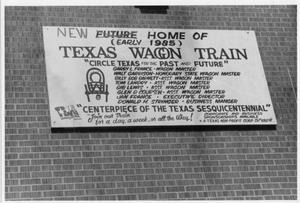Primary view of object titled 'Texas Sesquicentennial Wagon Train Headquarters Sign in Irving'.