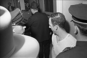 Primary view of object titled '[Lee Harvey Oswald in the hallway at the Dallas Police Department]'.