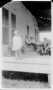 Photograph: [Mary Jones standing near the edge of a porch]