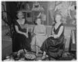 Photograph: [A group of women sitting near a piano at the Perry Brooks Hotel]
