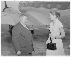 Primary view of object titled '[Julie Adams and man standing in front of plane]'.