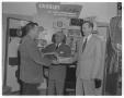 Primary view of [Men standing in front of radio display in store]