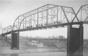 Primary view of object titled '[Brazos Bridge in Rosenberg. People are gathered on the bridge.]'.