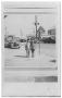 Photograph: [Boy and girl in front of street with Texaco Station]