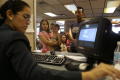 Thumbnail image of item number 1 in: '[Woman with computer assisting people in line]'.
