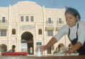 Primary view of [Vendor wipes off a table in front of the Fort Worth Mercado building]
