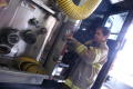 Photograph: [A fireman putting on his fire-fighting gear beside the fire truck]