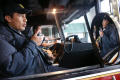 Photograph: [A fireman speaks with the dispatcher on the radio in his fire engine]