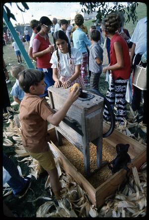 Primary view of [Children Learn How to Operate Antique Corn Sheller]