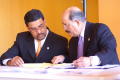 Photograph: [Hector Flores and another man reviewing papers at a table]