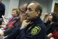 Photograph: [Officer of Dallas County Sheriff's Office listening to speakers]