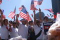 Primary view of [Immigration Protesters Carry Flags and Signs]