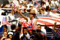Photograph: [Female protester waves American flag above the crowd]