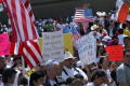 Photograph: [Protesters carry signs and the flags of the United States and Mexico]