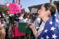 Photograph: [Woman wrapped in American flag addresses crowd]