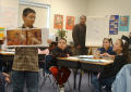 Photograph: [Student holds up a book in class to show everyone the pictures]