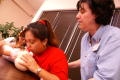 Photograph: [Instructor helps mothers during a first aid class]