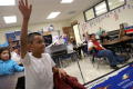 Photograph: [Students Raising Their Hands in a Class at Crockett Elementary]