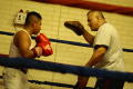 Photograph: [Young man in red boxing gloves practicing with instructor]