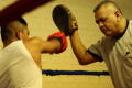 Photograph: [Young man practicing with boxing instructor]